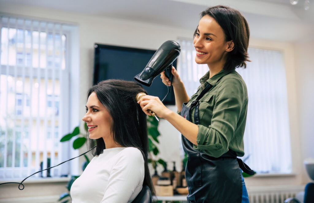 cosmetologist cutting hair in a salon